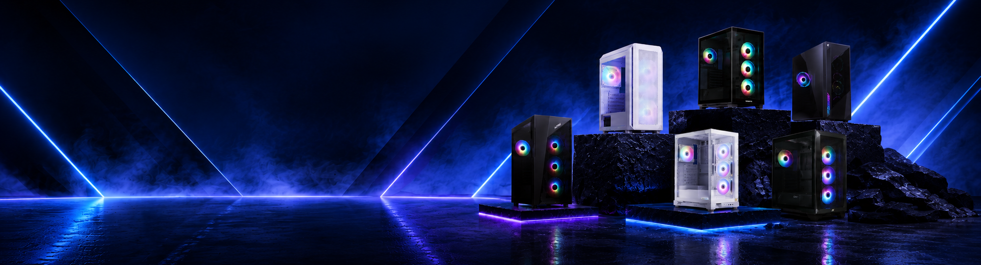A group of gaming PC towers with RGB lighting, displayed on dark pedestals in a dramatic, dark blue studio setting with neon light beams.